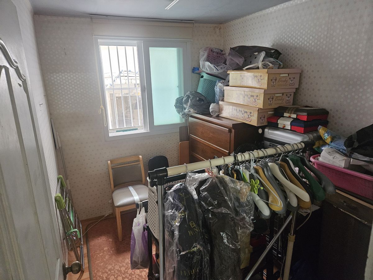 정리 전 옷걸이와 수납 상자로 찬 작은방